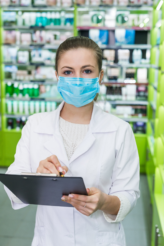 Woman pharmacist checking medication list in a pharmacy