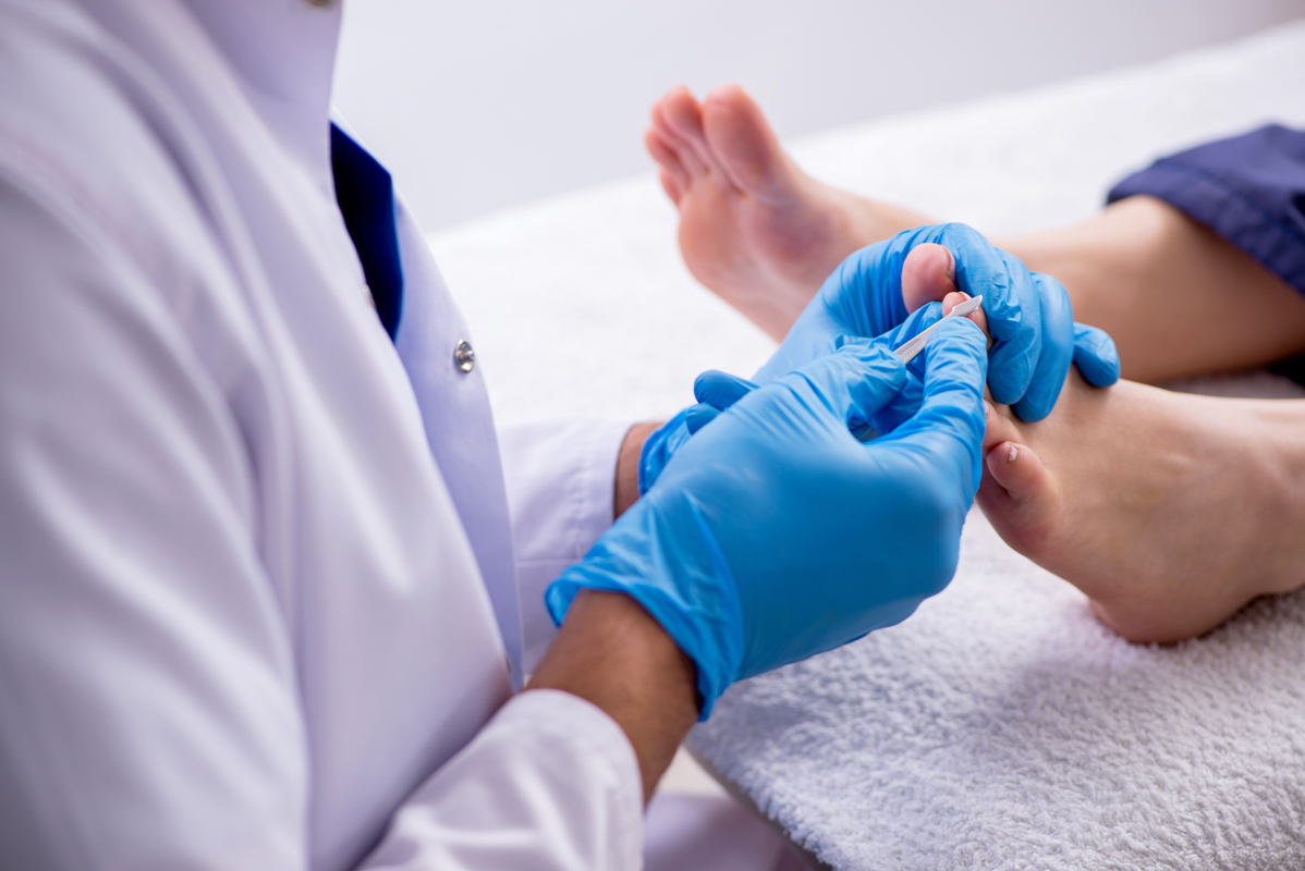 Podiatrist treating feet during the procedure